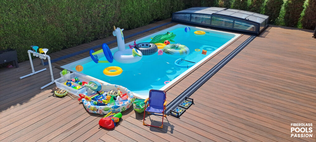 Rectangular fiberglass pool full of inflatable pool toys