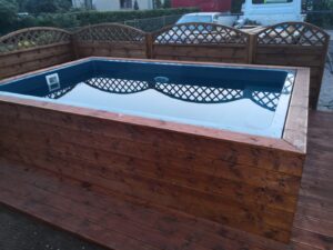 Fiberglass Bari pool from DreamPools installed as the semi - above the ground pool