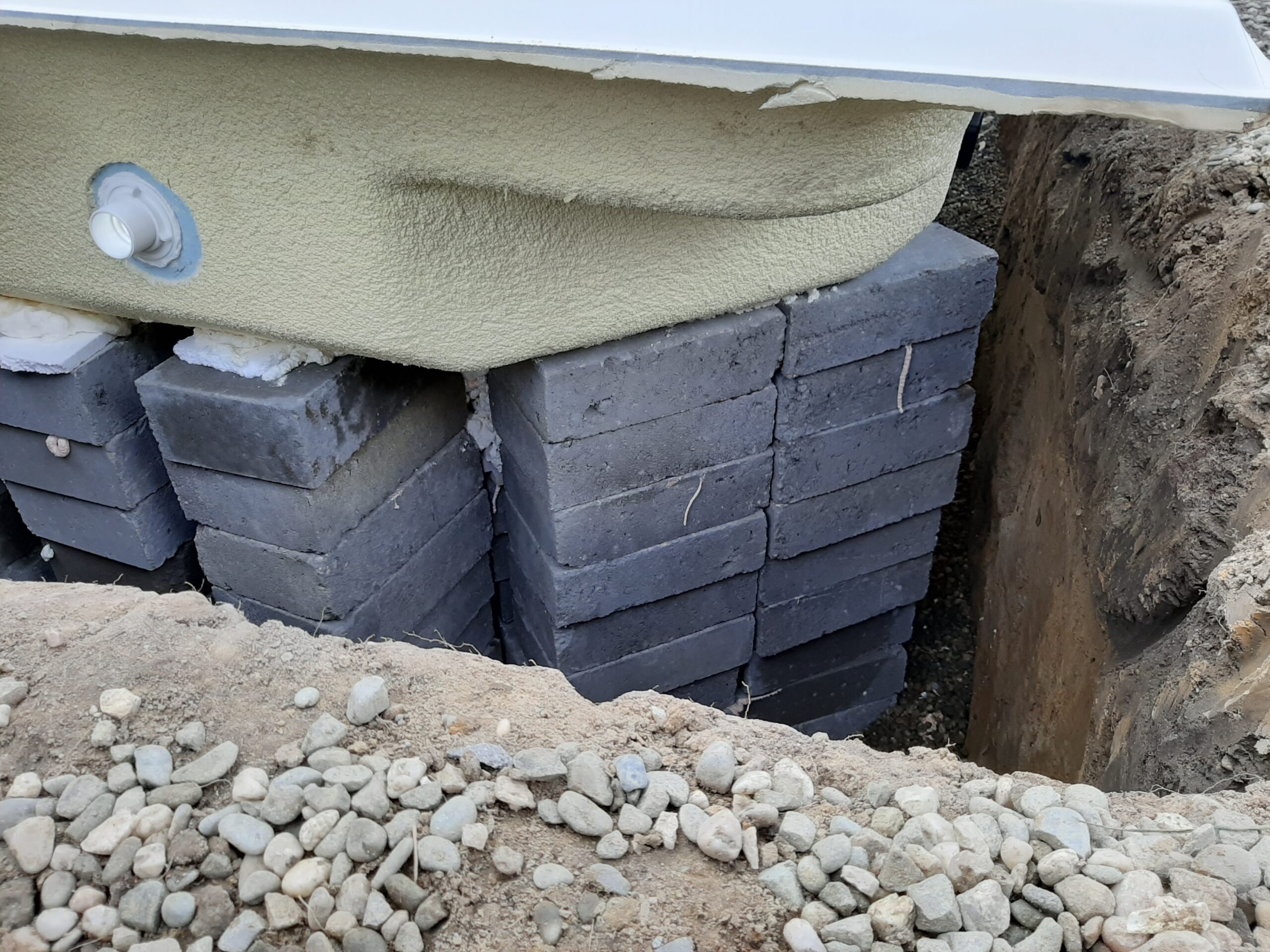 supporting the stairs in a polyester pool with concrete blocks