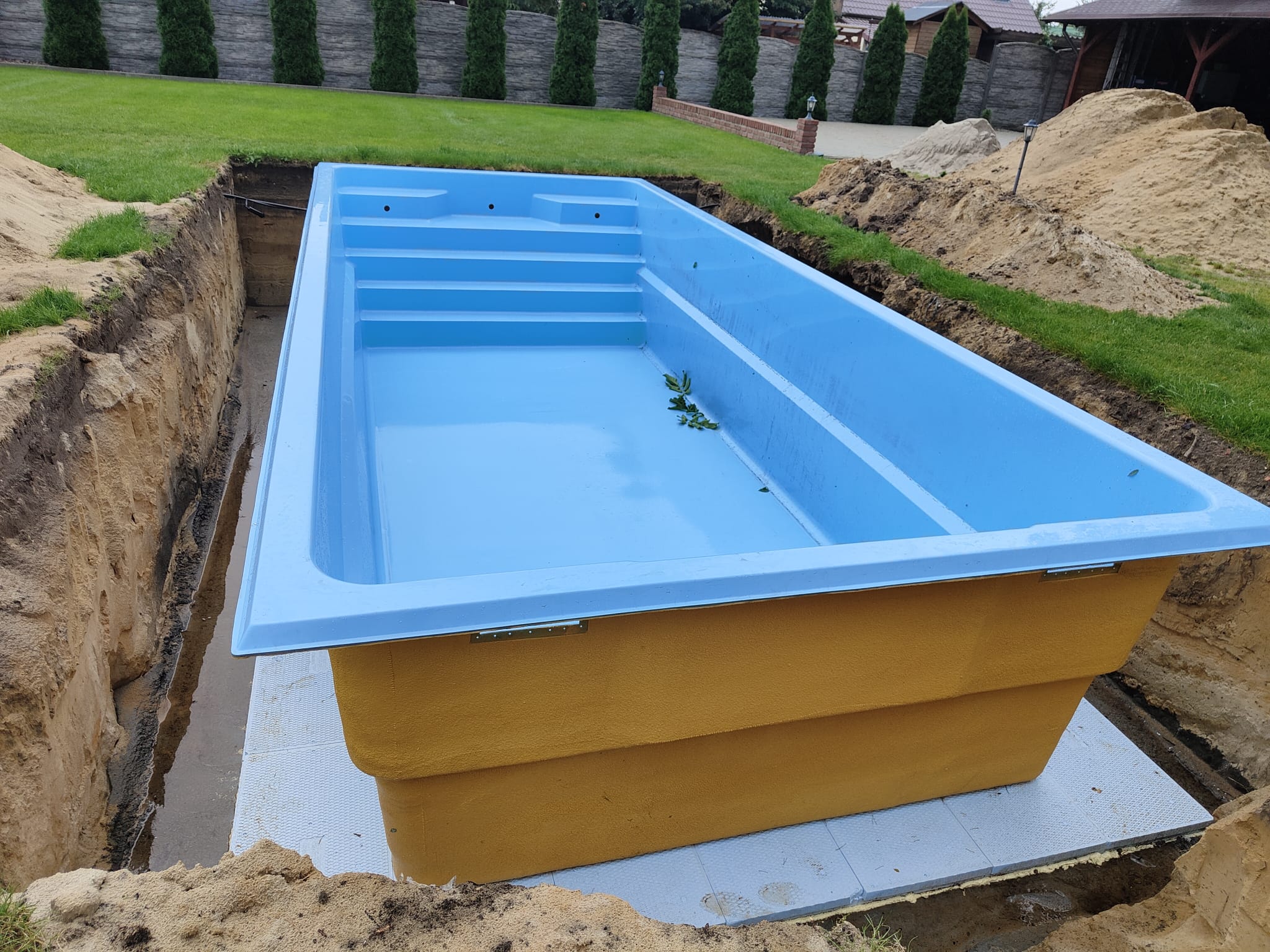 Venice polyester zwembad 8,50 x 3,70 x 1,55 m van DreamPools geplaatst in een sleuf en voorbereid voor installatie